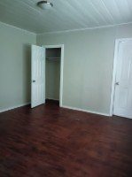 A room with a wooden floor and a white door.